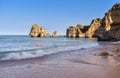 Cliffs of Pinhao Beach. View from below of the waves and empty sand at sunset. Concept of tourism and uncrowed travel. Algarve,