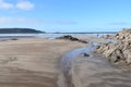 Seascape of low tide and beach rocks and rock pools. The sand is textured and patterned by the sea and wind. A BREATHTAKING VIEW.