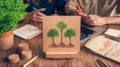 Climate activists planning environmental strategy, sketching tree preservation concept, work tools spread across rustic Royalty Free Stock Photo