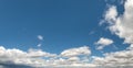 Climate contrast, rain clouds on horizon in big blue sky.