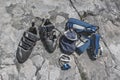 Climb gear equipment on rock. Climbing shoes, belaying carabiners, loops, ropes, bag for magnesia, belay system