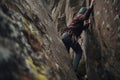 climber ascending steep wall, gripping the rocks with their hands and feet Royalty Free Stock Photo