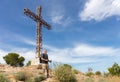 A climber with a backpack under the summit cross. Royalty Free Stock Photo