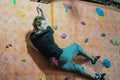 Climber in a boulder gym. Man climbing bouldering problem. Colorful volumes and holds on a white wall. Russia, Saratov - january, Royalty Free Stock Photo