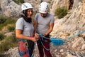 Climber boy checks his girl`s eight knot as she smirks flirtatiously at the camera Royalty Free Stock Photo