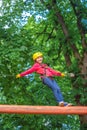 Climber child on training. Child climbing on high rope park. Cargo net climbing and hanging log. Children fun. Portrait