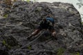 Climber climbing up a rocky mountain wall and aiming for the top Royalty Free Stock Photo