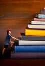 Climber climbs a heap of books Royalty Free Stock Photo
