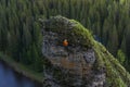 Climber descends from the top of a steep cliff above the river
