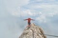 Climber finding his balance on top of a mountain ridge, surrounded by clouds, high on via ferrata Eterna, on Marmolada glacier Royalty Free Stock Photo