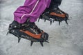 Climber on a frozen waterfall. Crampons close-up on his feet ice climber