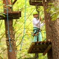 Climber girl engaged in training between trees