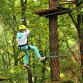 Climber girl engaged in training between trees