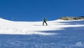 The climber goes on skis on a snowy slope to the climbing path where he will climb with two ice axes. Winter climbing in the