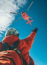 Climber greetings Medical Rescue helicopter landing in high altitude Himalayas mountains during mount expedition climbing. Travel Royalty Free Stock Photo