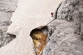 A climber is crossing a steep avalanche snow slope -On the way on the Alpini altitude path in the Sextener dolomites