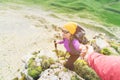 A climber helps a young mountaineer woman reach the top of the mountain. A man gives a helping hand to a woman. View