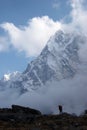 Climber looking at snow covered Cholatse mountain, Himalaya