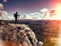 Climber outstretched on mountain top looking at landscape