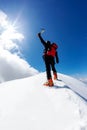 Climber reaches the summit of a snowy mountain peak