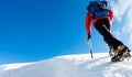 A climber reaches the top of a snowy mountain. Concept: courage, success, perseverance, effort, self-realization. Royalty Free Stock Photo