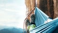 Climber resting in hammock on the vertical cliff wall Royalty Free Stock Photo