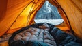 Climber rests inside insulated sleeping bag at alpine basecamp tent Royalty Free Stock Photo