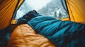 Climber rests inside insulated sleeping bag at alpine basecamp tent Royalty Free Stock Photo