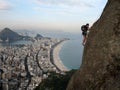 Climber on rock wall with Rio de Janeiro beaches on background