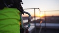 Climber on rooftop attaches carabiner to loop on equipment