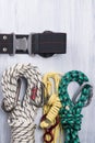 Climber`s belt with different ropes and carbines for insurance lie on a light background