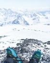 Climber`s legs in high-rise boots and cats against the backdrop of mountains