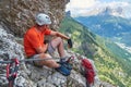 Climber taking a break on via ferrata dei Finanzieri, in Dolomites mountains, above Alba di Penia, Italy, during Summer Royalty Free Stock Photo