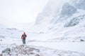 Climber walks alone in high mountains at windy snowy weather Royalty Free Stock Photo