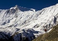 A climber walks through the annapurnas mountains in nepal towards lake tilicho with a spectacular view of the tilicho peak in the