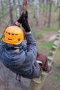 Climber walks on logs holding safety rope