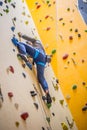 Climber on wall.Young man practicing rock climbing on a rock wall indoors Royalty Free Stock Photo