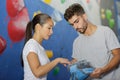 Climber woman and man coating hands in powder chalk