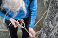 Climber woman in safety harness tying rope in bowline knot Royalty Free Stock Photo