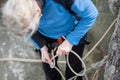 Climber woman in safety harness tying rope in bowline knot Royalty Free Stock Photo