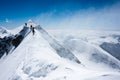 Climbers balancing in blizzard Royalty Free Stock Photo