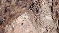 Climbers climb the rock. Drone footage. Side and top view. Rock lesson in the highlands. Gray rocks and dry bushes. Sometimes ther Royalty Free Stock Photo