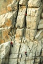 Climbers conquering challenging rock formations in mountain.