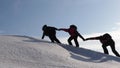 Climbers hand in hand climb to top of a snowy mountain. the team of travelers in winter go to their goal of overcoming Royalty Free Stock Photo
