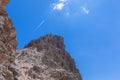 Climbers and hikkers climb to the top of the Sassongher mountain against the blue sky.