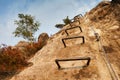 Climbers metal ladder via ferrata. Iron twisted rope fixed in block by screws snap hooks. The rope end anchored into sandstone Royalty Free Stock Photo