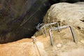 Climbers metal ladder via ferrata. Iron twisted rope fixed in block by screws snap hooks. The rope end anchored into sandstone Royalty Free Stock Photo