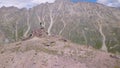 Climbers stopped to rest in mountains. Clip. Tourists on ascent to mountains stopped to rest on rocky ledge Royalty Free Stock Photo