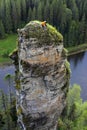 Climbers at the top of a steep cliff above the river