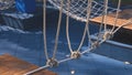 Climbing rope with vintage outdoor wooden playground equipment on blue rubber tile floor in public park area Royalty Free Stock Photo